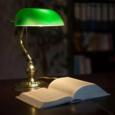 Banker lamp at home Banker lamp with an open book at home coffee table